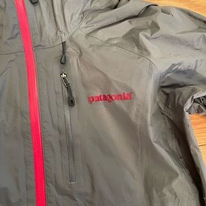Patagonia 100% nylon grey raincoat with pink accents.